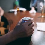 眠れずにお酒を飲む人物と、不安げな表情を浮かべる夜のイメージ