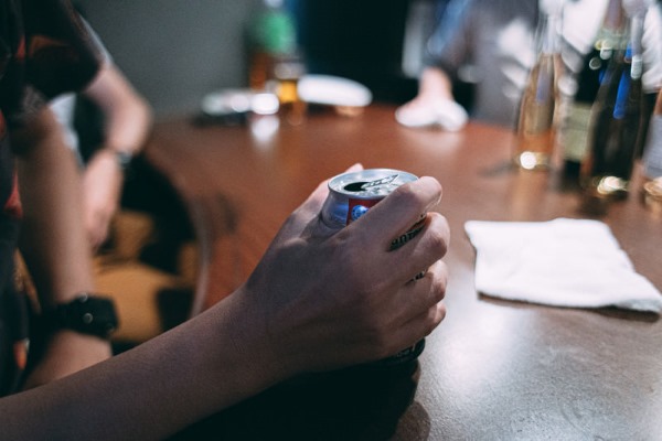 眠れずにお酒を飲む人物と、不安げな表情を浮かべる夜のイメージ