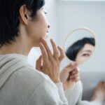 顔のシミに悩む中年女性と美白スキンケア用品のイメージ