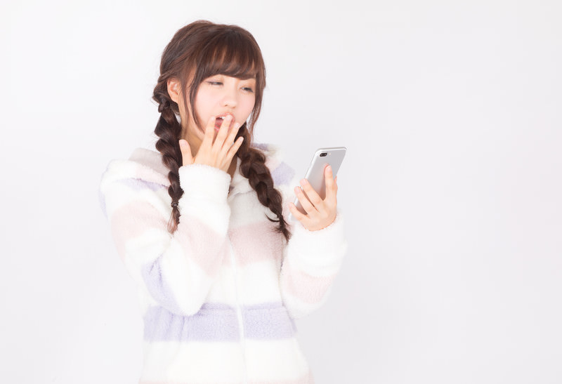 スマートフォンのショート動画を夢中で見続ける若者の姿と脳のイメージを組み合わせたビジュアル